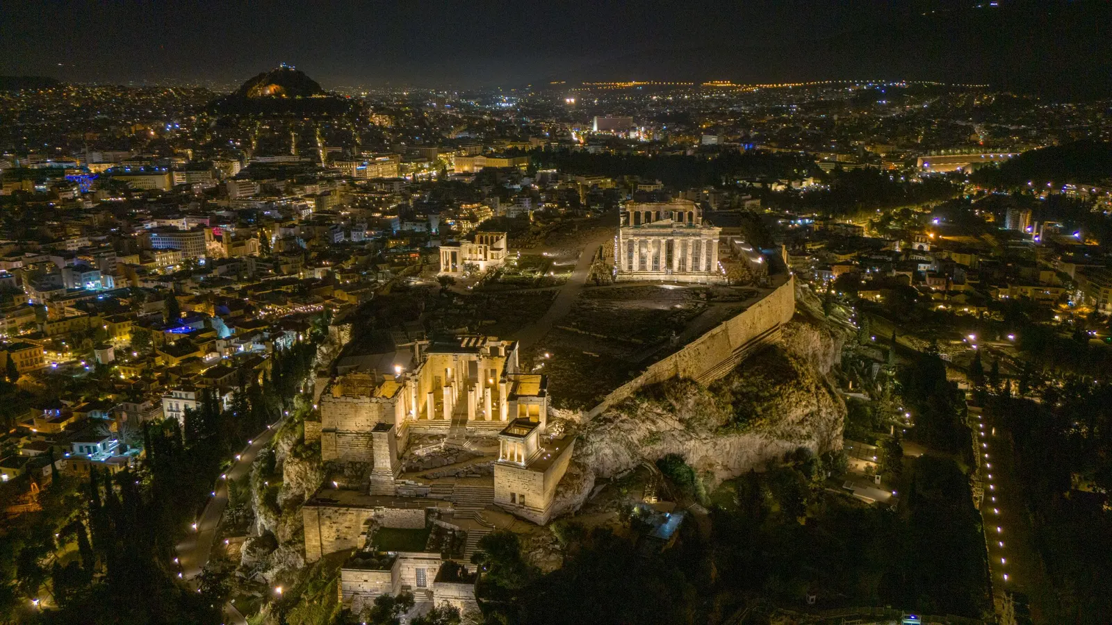 The Acropolis of Athens at night, with Lycabettus hill behind
